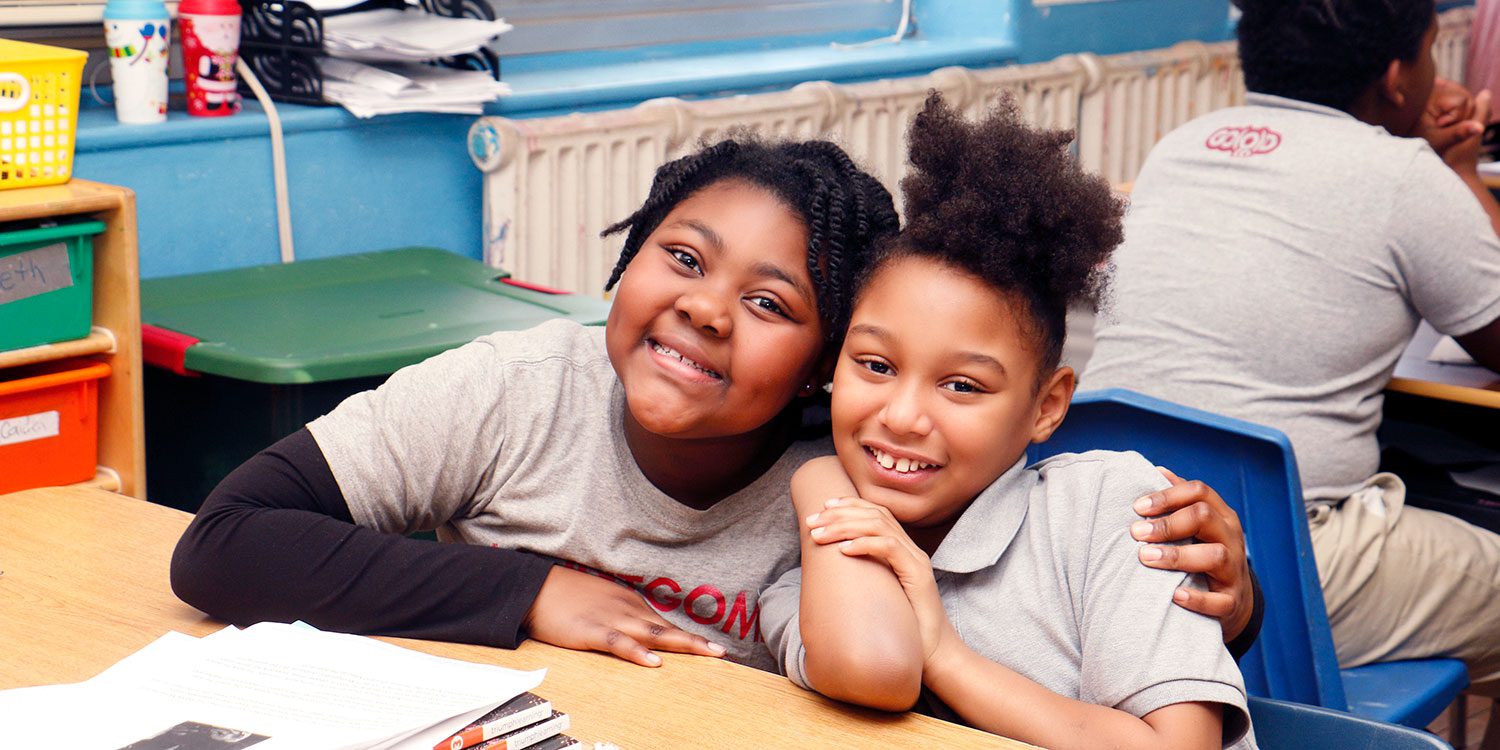 Smiling students in a classroom.